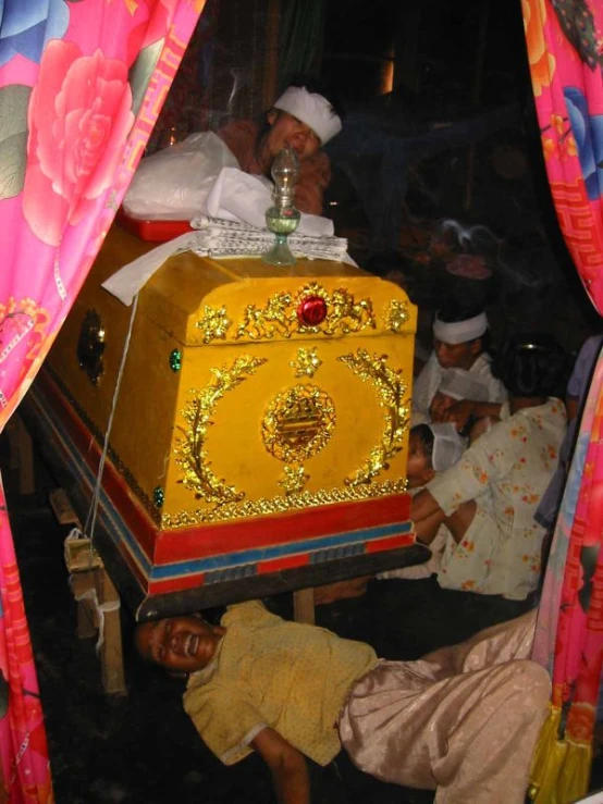 an image of a man laying on the ground next to a large trunk