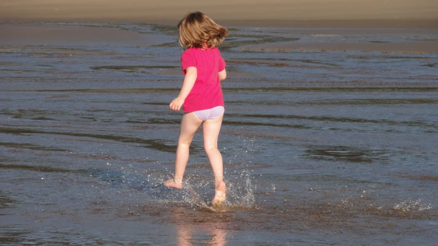 a little girl that is playing in the water