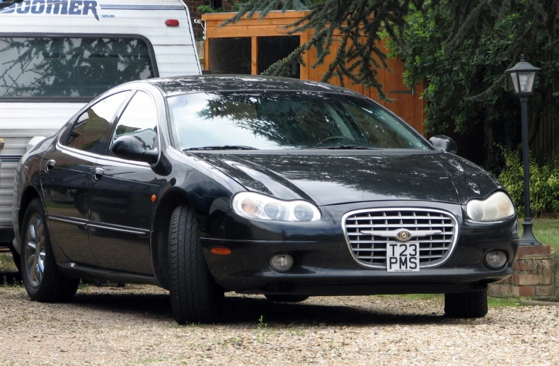 a black car parked in front of an rv