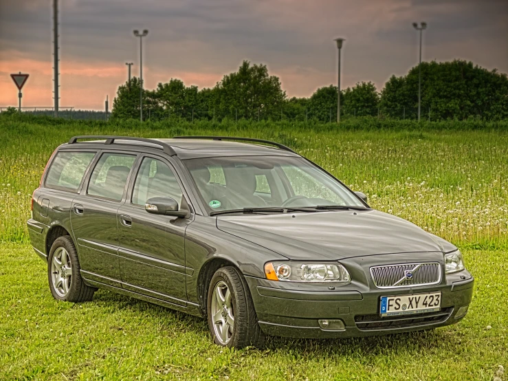 a green volvo vw wagon sitting in a grassy field