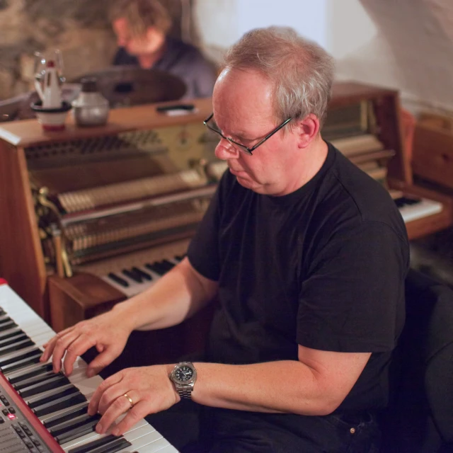 an old man is playing a piano organ