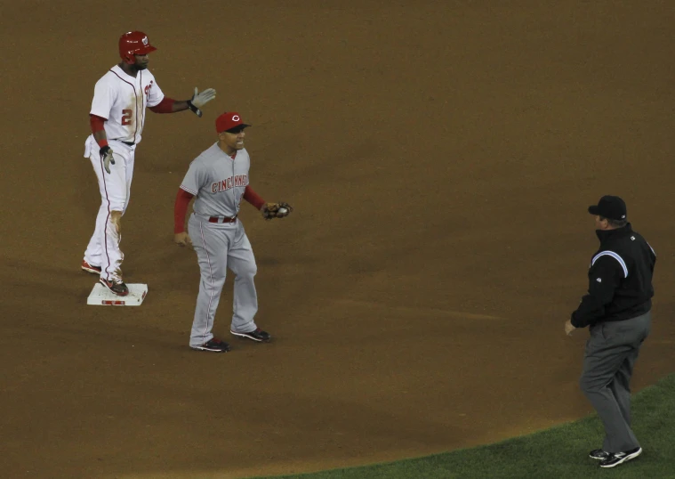 a couple of baseball players standing on a field