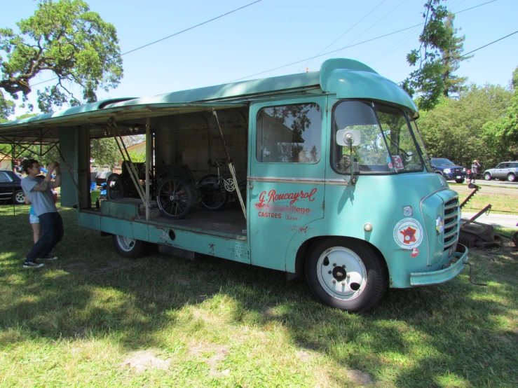 an old green truck has two bicycles on the back