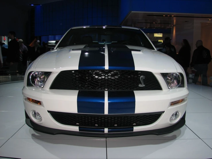 the white and black mustang car with blue stripeing