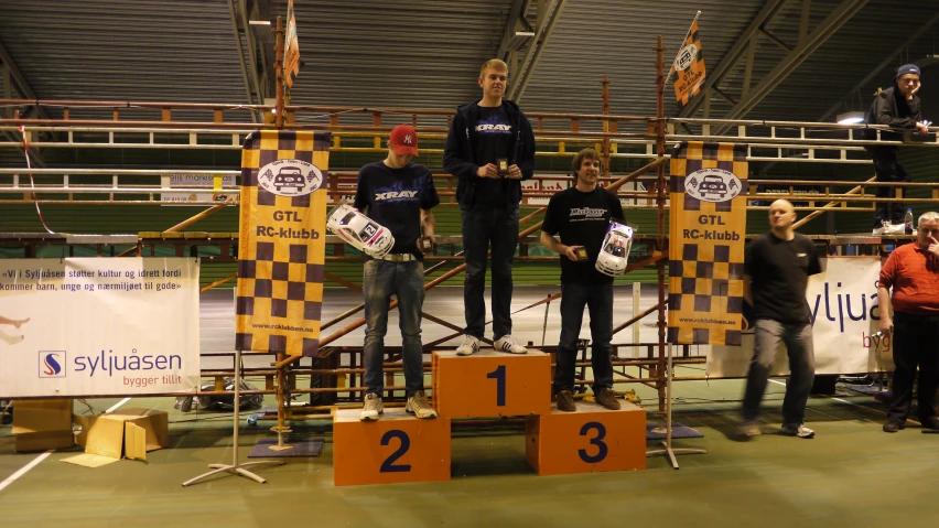 four people standing on a podium during a competition