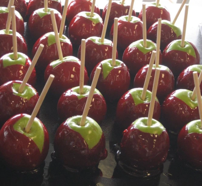 a tray with many shiny red apples and tooth picks