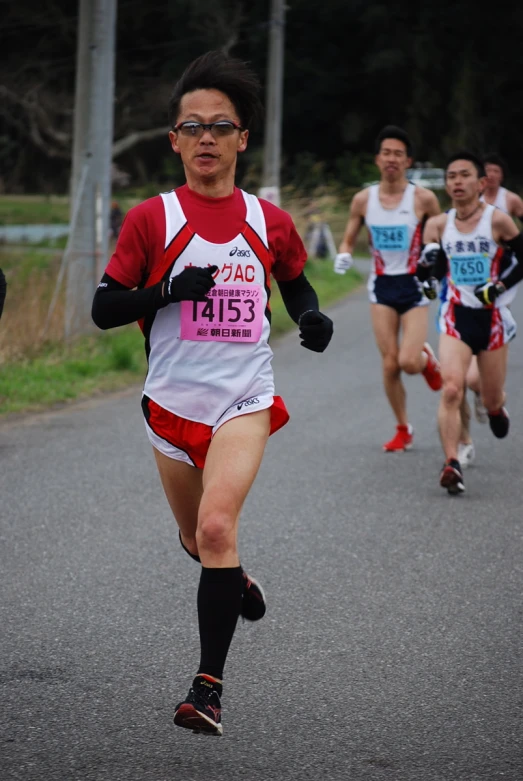 men running in a race on a paved path