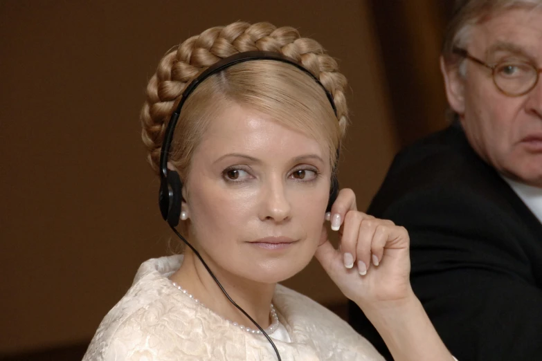 a woman wearing a headset with an older man behind her