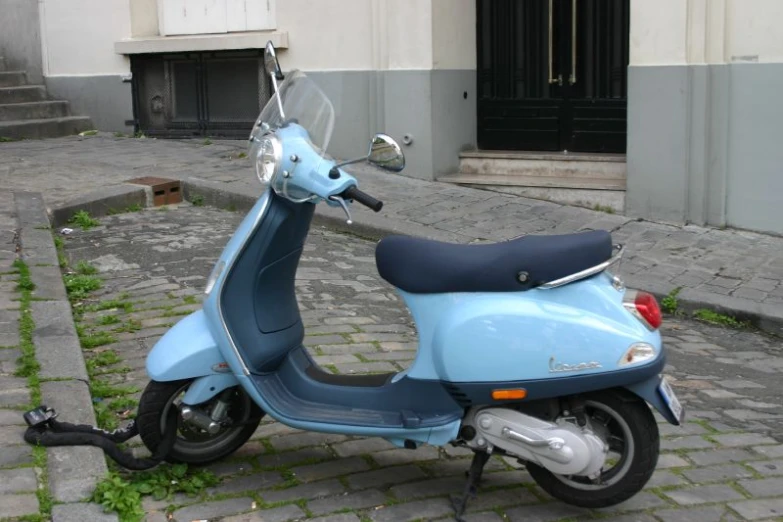 blue motorcycle parked outside of an apartment building