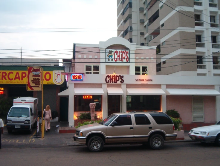 cars and trucks outside of business near multiple parking spots