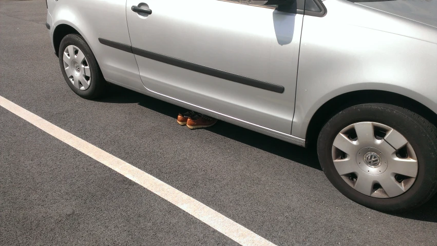 a small silver car is parked next to a fire hydrant