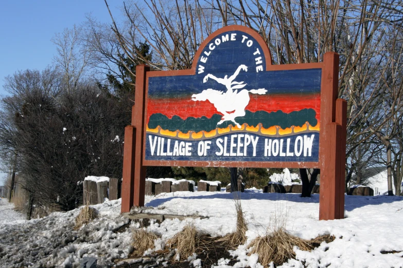 a sign in front of a tree is covered with snow