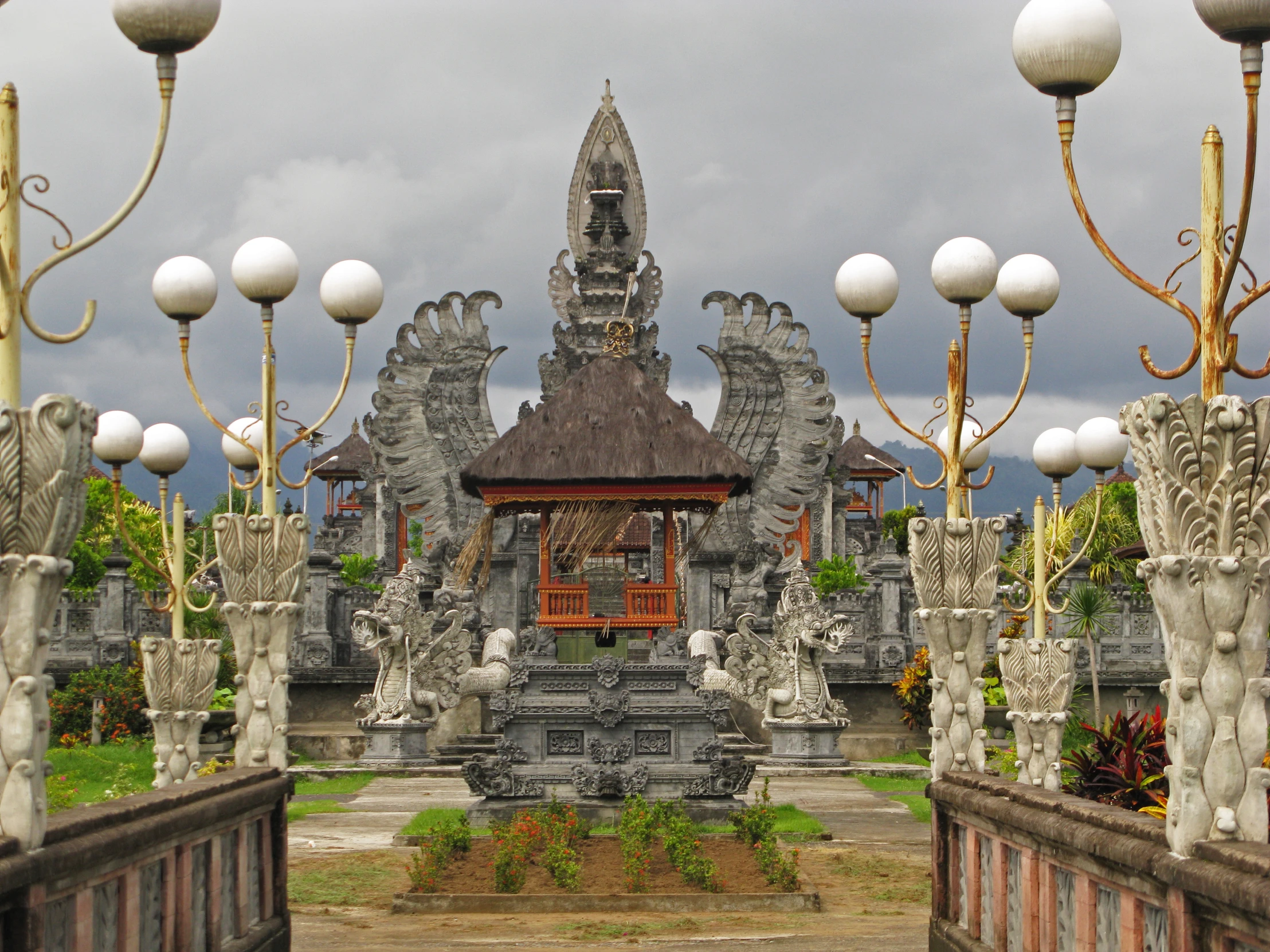 an ornate structure sits at the end of some cement bridges