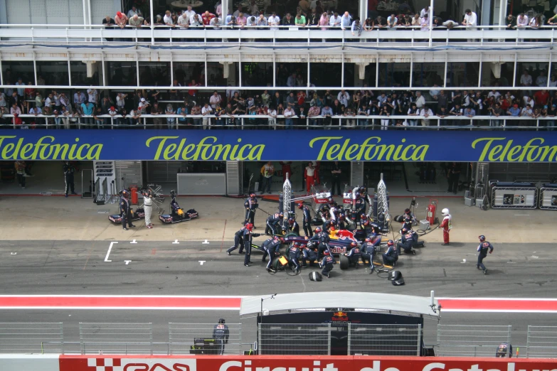 a number of motorcycles on a street with people watching