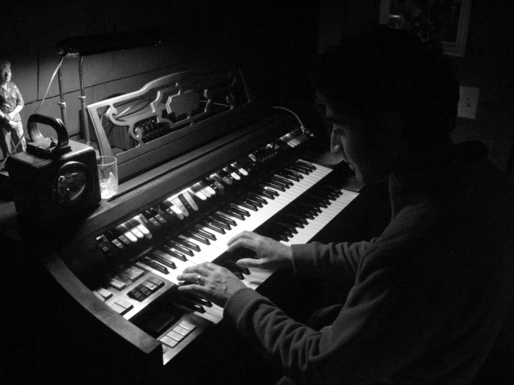 the man is playing a musical instrument and playing the piano