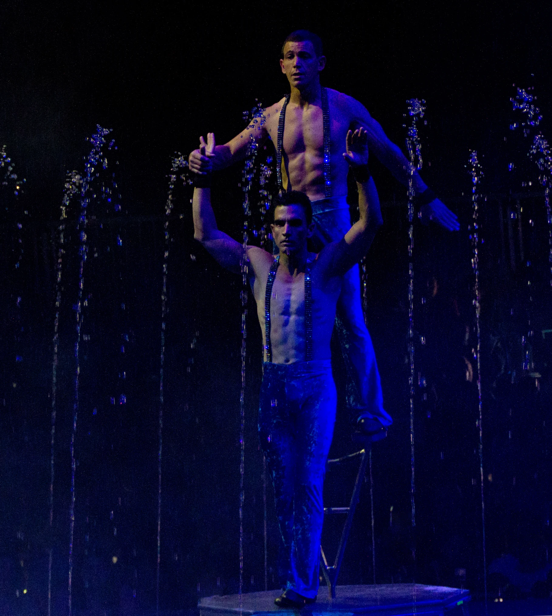 two men are holding up their hands on a stage