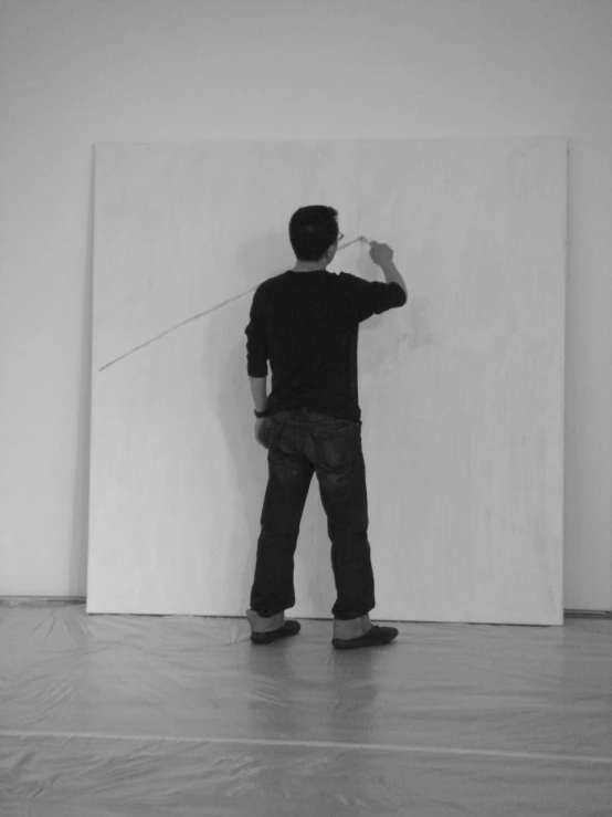 a man is standing in an empty room, working on a mural