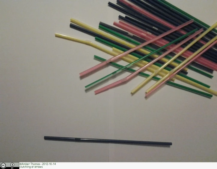 several sticks are next to a pen on a wall