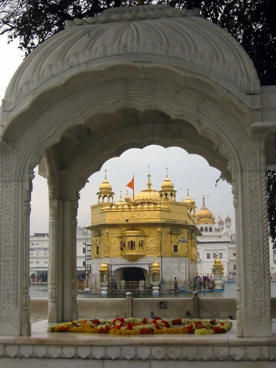 the building has arches, pillars, and a golden dome on top of it