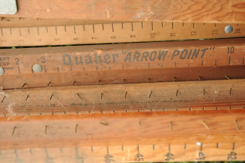 three tall wooden rulers are on a piece of wood