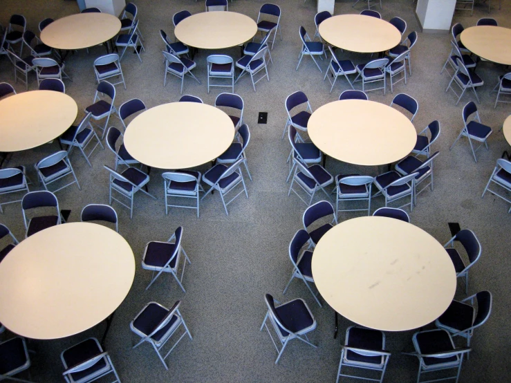 empty tables and chairs are arranged in a large room