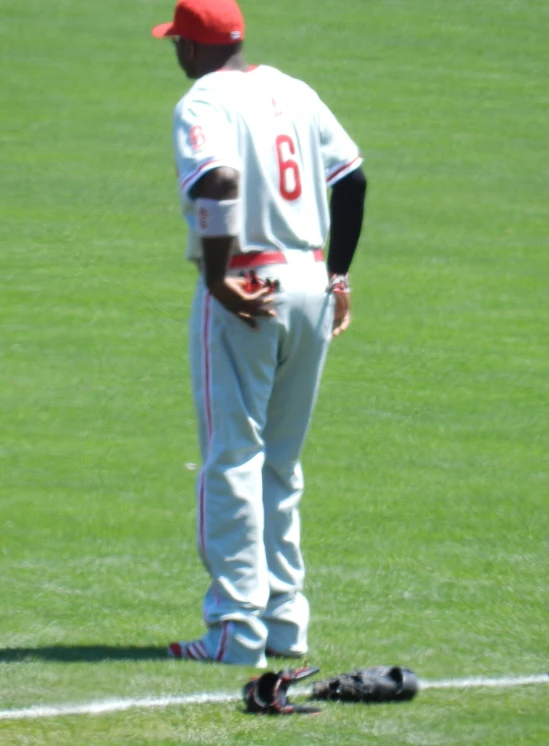 a baseball player looks down as he stands on a field