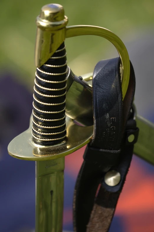 a metal hook on top of a wooden pole with leather straps