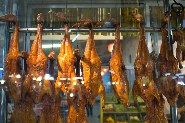 some meat hanging on a rack outside in the rain