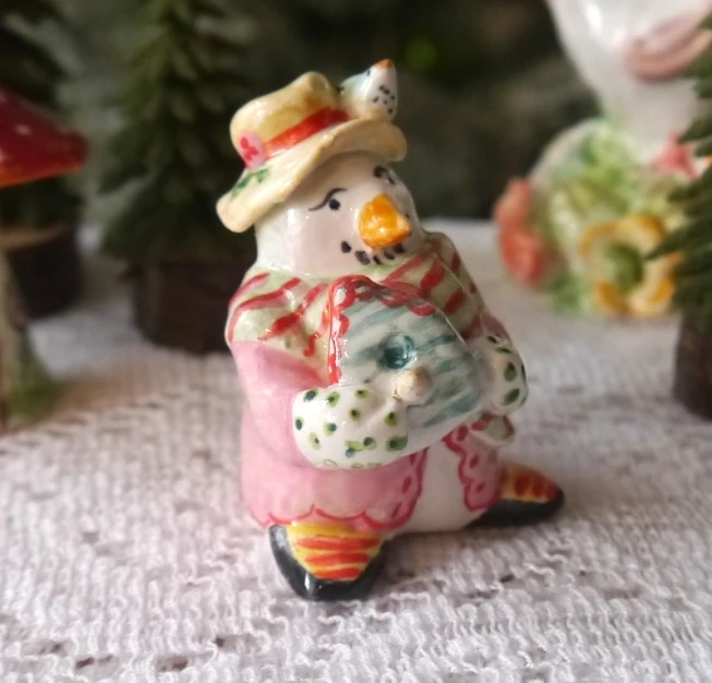 a tiny toy figurine with a hat and scarf