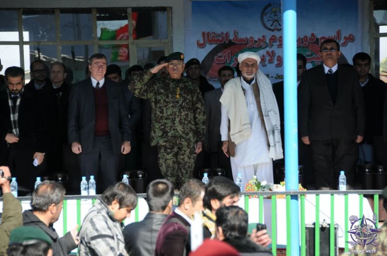 a group of people standing together and one is wearing uniform