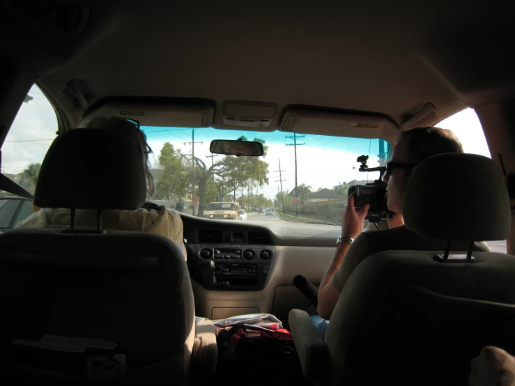 two women drive their dogs through traffic while holding up cameras