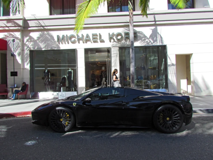 a black sports car parked in front of a store