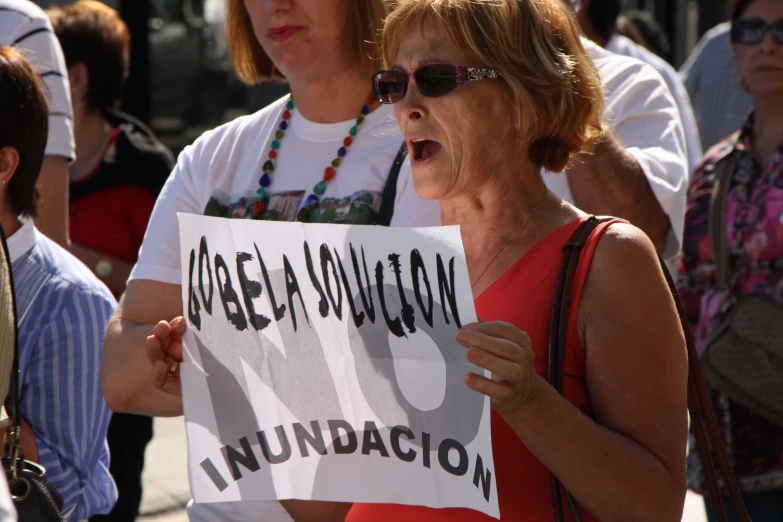 a woman holding a protest sign and shouting