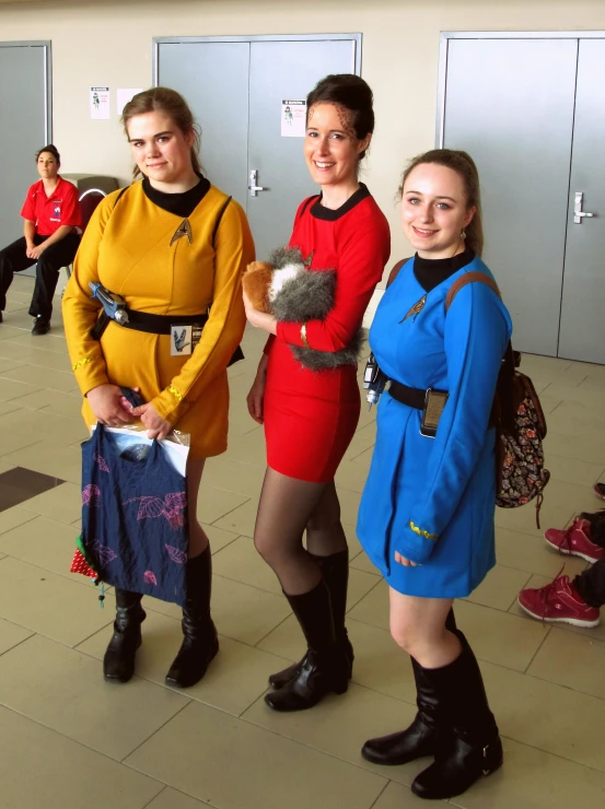 three ladies standing next to each other in costumes