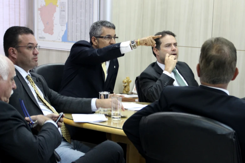 a man in a suit pointing his hand at others