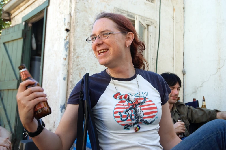 a woman with glasses smiles while sitting