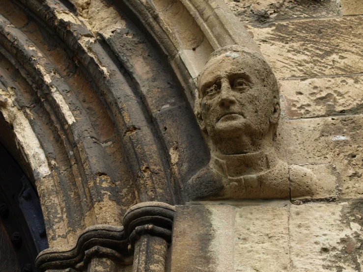 an old and damaged statue on the side of a building