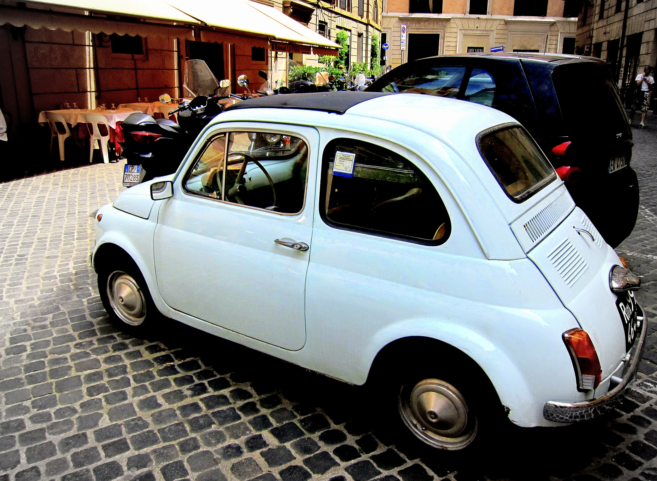 a small white car parked along a street