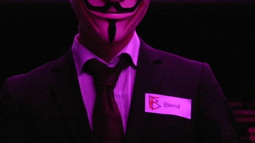 a man wearing a suit with a fake mask over his face