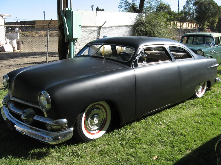 an antique car is parked in the grass