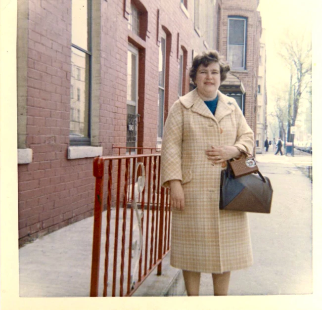 a woman is standing in front of a fence