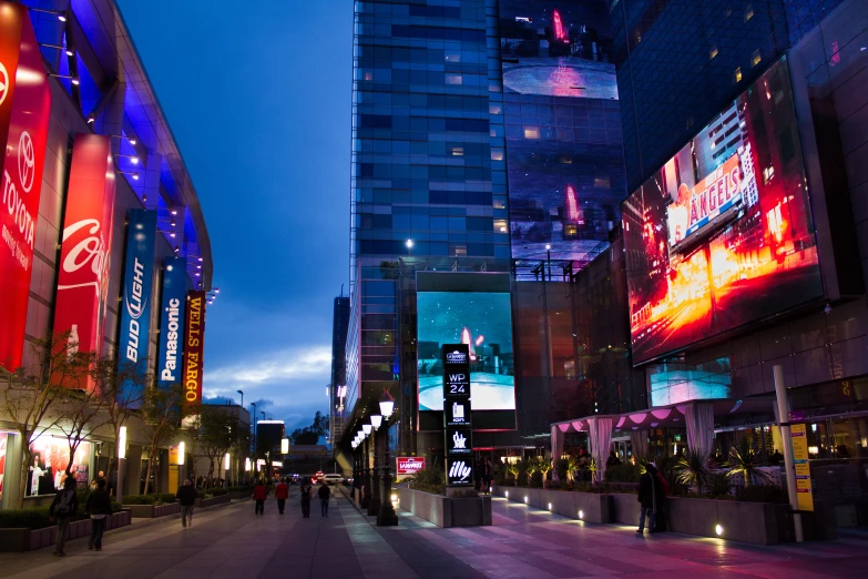 a street filled with tall buildings next to a lighted traffic light