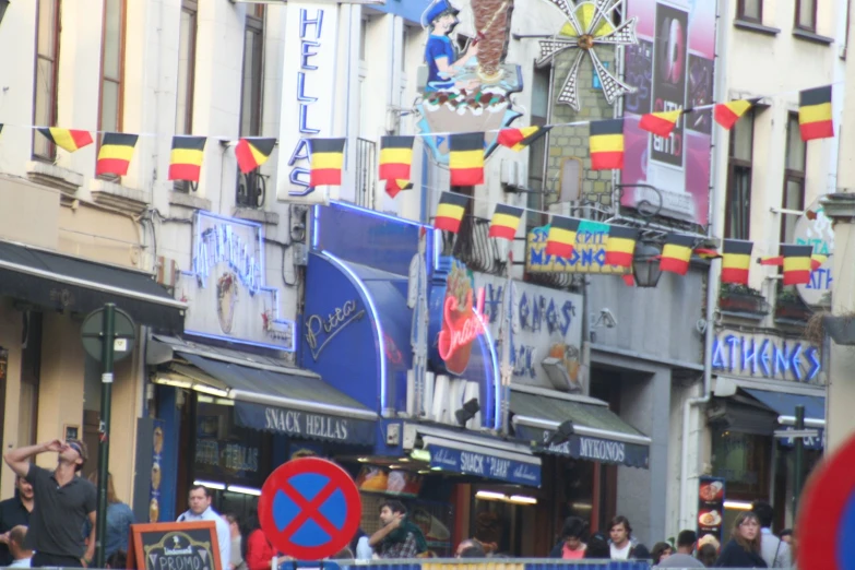 many people on street and buildings with flags in the air