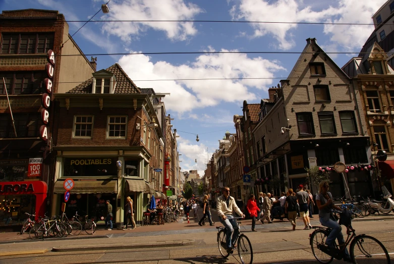 three people riding bicycles in front of a storefront