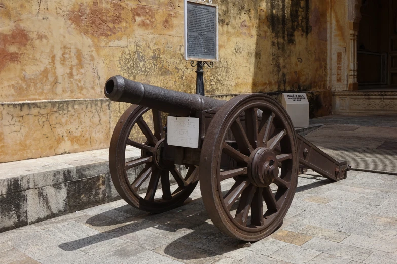 an old wooden cannon is standing outside the building