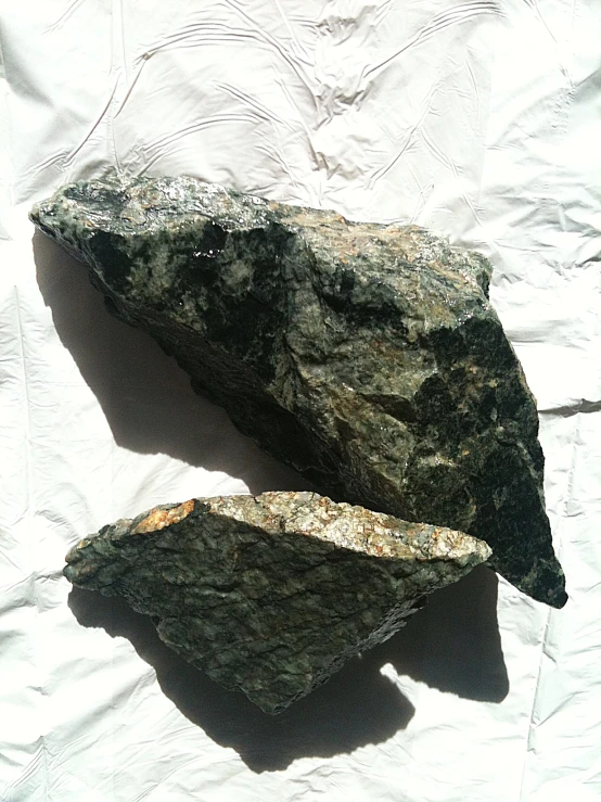 two rock type objects are sitting on the ground