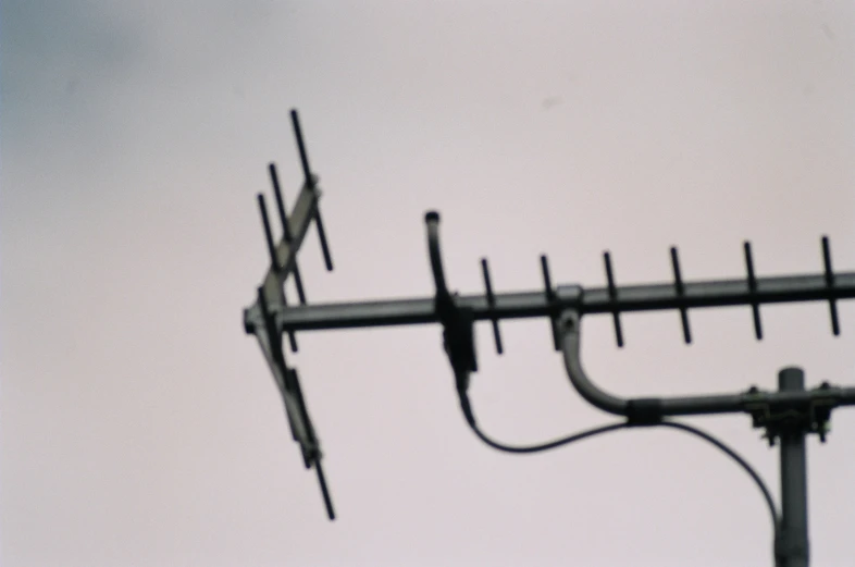 an antenna in the middle of the day with white skies