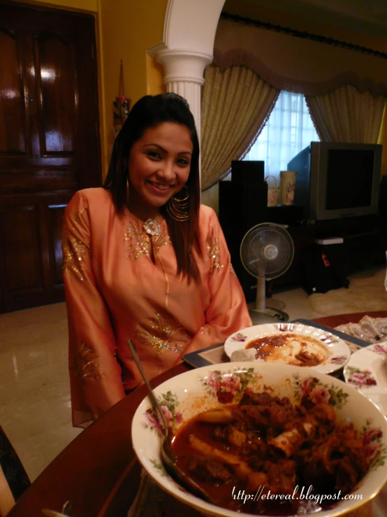 a woman standing next to a table with food