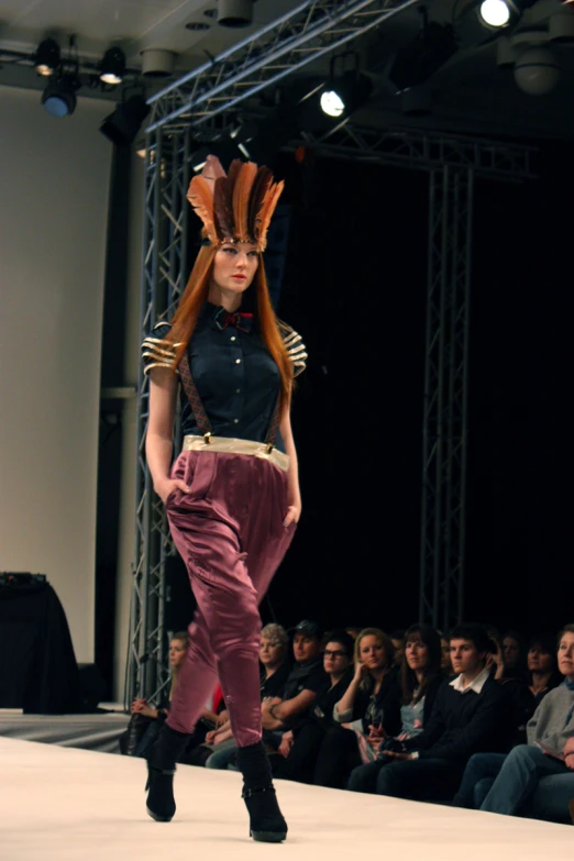 a person standing on a runway wearing long brown hair