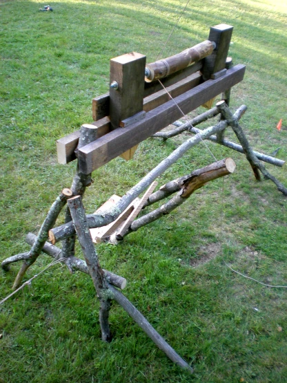 a bench made out of logs is in the grass